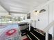 Patio with hot tub, ceiling fan, and steps to a bright white front door at 1312 Apache Cir, Tavares, FL 32778