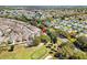 An aerial view of a suburban community bordering a golf course, showcasing mature trees at 1502 Aalto Pl, Lady Lake, FL 32159