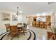 Dining area with bar seating features tile floors, a round rug, and seamless flow to the kitchen at 1502 Aalto Pl, The Villages, FL 32159