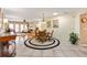 Open-concept dining area with tile floors, round rug, and natural light pouring in from the adjacent living area at 1502 Aalto Pl, The Villages, FL 32159