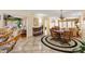 Bright dining area features tile flooring, a round rug, and wicker chairs adjacent to an inviting living space at 1502 Aalto Pl, Lady Lake, FL 32159