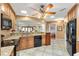 Beautiful kitchen boasting granite countertops, wood cabinetry, tile floors, and stainless steel appliances at 1502 Aalto Pl, Lady Lake, FL 32159