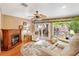 Relaxing living room features a fireplace, ceiling fan, and sliding glass doors to the outdoor space at 1502 Aalto Pl, The Villages, FL 32159