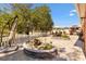 Spacious brick patio with a water feature, dining and lounge seating, landscaping and mature trees at 1502 Aalto Pl, The Villages, FL 32159