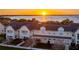 Stunning aerial view of the townhome complex with a beautiful sunset over the water in the background at 164 Nautica Mile Dr, Clermont, FL 34711