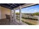 A covered balcony with seating offers serene views of the lake at 164 Nautica Mile Dr, Clermont, FL 34711