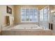 Bathroom featuring a large tub, walk-in shower, plantation shutters, and scenic water views at 164 Nautica Mile Dr, Clermont, FL 34711