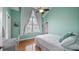 Cozy bedroom featuring wood floors, a ceiling fan, and a large window with elegant white curtains at 164 Nautica Mile Dr, Clermont, FL 34711