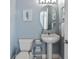 Compact half-bathroom, featuring updated fixtures, mirror, and a pedestal sink at 164 Nautica Mile Dr, Clermont, FL 34711