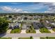 Expansive aerial shot capturing numerous homes in a vibrant residential neighborhood under a blue sky at 16721 Se 77Th Northridge Ct, The Villages, FL 32162