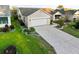 Aerial view of a well-maintained single-story home features a patterned driveway, manicured lawn and lush landscaping at 16721 Se 77Th Northridge Ct, The Villages, FL 32162