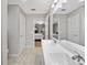Bright bathroom featuring a double vanity sink, tile flooring, and a view into an adjacent bedroom at 16721 Se 77Th Northridge Ct, The Villages, FL 32162