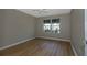 Neutral bedroom with wood-look floors and a bright window view at 16721 Se 77Th Northridge Ct, The Villages, FL 32162