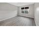 Empty bedroom with clean, gray vinyl floors and a large window letting in natural light at 16721 Se 77Th Northridge Ct, The Villages, FL 32162