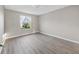 Bright, empty bedroom with clean, gray vinyl floors and a window letting in natural light at 16721 Se 77Th Northridge Ct, The Villages, FL 32162