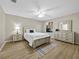 Cozy bedroom features hardwood floors, a ceiling fan, and large windows, creating a bright and inviting space at 16721 Se 77Th Northridge Ct, The Villages, FL 32162