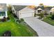 Aerial view of a well-maintained single-Gathering home with a two car garage, manicured lawn and mature landscaping at 16721 Se 77Th Northridge Ct, The Villages, FL 32162