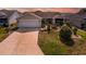 Beautiful home featuring a two-car garage, manicured lawn, and lovely landscaping for great curb appeal at 16721 Se 77Th Northridge Ct, The Villages, FL 32162