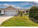 Beautiful home featuring a two-car garage, manicured lawn, and lovely landscaping for great curb appeal at 16721 Se 77Th Northridge Ct, The Villages, FL 32162