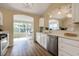 Sunlit kitchen featuring stainless steel appliances, white cabinets, and quartz countertops at 16721 Se 77Th Northridge Ct, The Villages, FL 32162