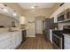 Bright kitchen with stainless steel appliances, wood flooring and white cabinets at 16721 Se 77Th Northridge Ct, The Villages, FL 32162