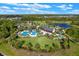 Aerial view of a community featuring a pool, playground, pond, and lush landscaping at 17024 Goldcrest Loop, Clermont, FL 34714