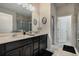 Bathroom featuring double sinks, dark wood cabinets, a glass shower, and modern fixtures at 17024 Goldcrest Loop, Clermont, FL 34714