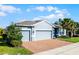 Lovely single-story home featuring a brick driveway, well-maintained lawn, and blue paint at 17024 Goldcrest Loop, Clermont, FL 34714