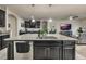 Open-concept kitchen featuring a large island with a sink and dark cabinetry, connecting to the living area at 17024 Goldcrest Loop, Clermont, FL 34714