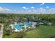 Aerial view of a resort-style pool and clubhouse in a lushly landscaped community at 17024 Goldcrest Loop, Clermont, FL 34714