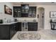 Wet bar with granite counters, wine refrigerator, dark cabinets and glass shelving at 17024 Goldcrest Loop, Clermont, FL 34714