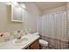 Bright bathroom with decorative tiles, a white sink, a functional toilet, and a shower curtain at 1729 Lauren Ln, Lady Lake, FL 32159