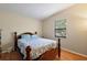 Cozy bedroom features a wooden bed frame, light blue bedding, and natural light from the window at 1729 Lauren Ln, Lady Lake, FL 32159