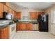 This kitchen features wooden cabinets, tile flooring, and modern appliances, including a black refrigerator at 1729 Lauren Ln, Lady Lake, FL 32159