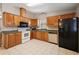 Well-lit kitchen features wooden cabinets, tile flooring, and modern appliances, including a black refrigerator at 1729 Lauren Ln, Lady Lake, FL 32159