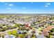 An aerial view of a community shows single-Gathering homes, green spaces, and serene ponds under a blue sky at 1797 Pamplico Ct, The Villages, FL 32162