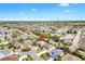 Aerial view showcases a residential neighborhood, highlighting the layout of homes and community amenities at 1797 Pamplico Ct, The Villages, FL 32162