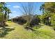 A view of the backyard shows a screened-in back porch with a manicured lawn at 1797 Pamplico Ct, The Villages, FL 32162