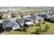 An aerial view of many single-Gathering homes featuring mature lawns and solar panels in a tranquil neighborhood at 203 Silver Maple Rd, Groveland, FL 34736