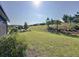 Wide shot of the landscaped backyard with a gentle slope and mature trees at 203 Silver Maple Rd, Groveland, FL 34736