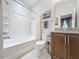 Bright bathroom featuring a granite-topped vanity and a tub and shower combination with a shower curtain at 203 Silver Maple Rd, Groveland, FL 34736