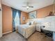 Cozy bedroom features a ceiling fan, a study desk and chair, plus a large bed with decorative pillows at 203 Silver Maple Rd, Groveland, FL 34736