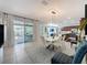 Bright dining area features a modern white table and chairs and sliding glass doors to a covered patio at 203 Silver Maple Rd, Groveland, FL 34736