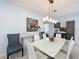 Bright dining area features modern decor and a glass table with six white chairs at 203 Silver Maple Rd, Groveland, FL 34736