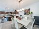 Bright dining area next to modern kitchen and features a glass table with six white chairs at 203 Silver Maple Rd, Groveland, FL 34736