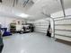 Spacious three-car garage with epoxy floor, golf cart, and storage racks at 203 Silver Maple Rd, Groveland, FL 34736