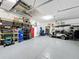 Organized garage with epoxy flooring, ample storage, and a golf cart at 203 Silver Maple Rd, Groveland, FL 34736