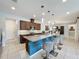 Modern kitchen featuring an eat-in island, granite countertops, stainless appliances, and tile flooring at 203 Silver Maple Rd, Groveland, FL 34736