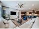 Bright, open concept living room featuring a large TV, comfortable seating, and easy kitchen access at 203 Silver Maple Rd, Groveland, FL 34736