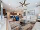 Bright living room featuring a ceiling fan, textured rug, and open access to the kitchen at 203 Silver Maple Rd, Groveland, FL 34736